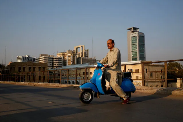 Journalist Arif Balouch, 48, poses for a photograph with his 1980 model Vespa scooter in Karachi, Pakistan, March 2, 2018. “For me, a Vespa scooter is like a family tradition. My father used to ride this and I myself find this very good as it has two separate comfortable seats which is uncommon, it has a compartment to keep things which is also uncommon and for safety it guards your knees during accidents. I would say it's the BMW of scooters”, Balouch said. (Photo by Akhtar Soomro/Reuters)