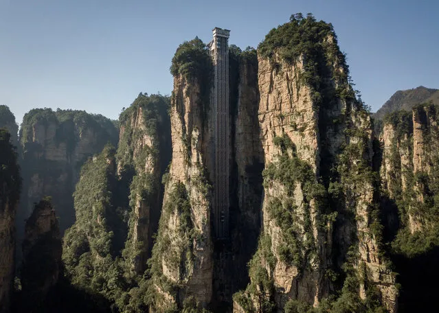 This picture taken on November 13, 2020 shows shows an aerial view of the Bailong elevators in Zhangjiajie, China's Hunan province. Towering more than 300 metres (1,000 feet) up the cliff face that inspired the landscape for the blockbuster movie “Avatar”, the world's highest outdoor lift whisks brave tourists to breathtaking views. (Photo by Wang Zhao/AFP Photo)