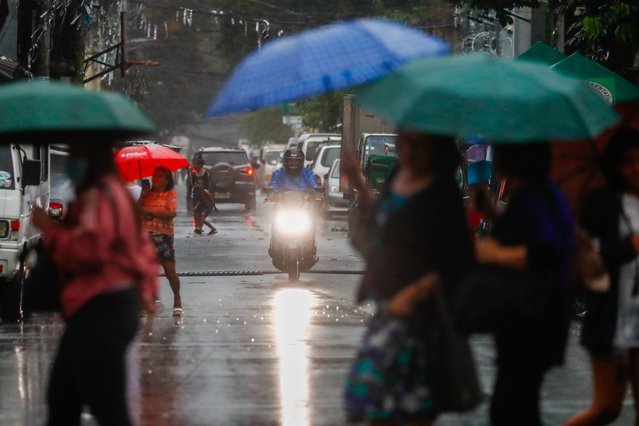 People holding umbrellas struggle against heavy rains and strong winds, as Super Typhoon Ragasa slashes the Southeast Asian archipelagic country, in Metro Manila, Philippines, on September 23, 2025. The powerful tropical storm is expected to bring destructive winds and heavy rains to several parts of East Asia, including mainland China, the Asian financial hub of Hong Kong and parts of Taiwan Island. (Photo by Daniel Ceng/Anadolu via Getty Images)