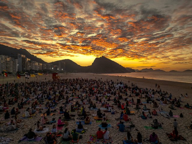 An aerial view shows people taking part in the “Yoga ao Sol Nascer” (Yoga at Sunrise) event at Copacabana beach in Rio de Janeiro, Brazil, on June 22, 2024. (Photo by Mauro Pimentel/AFP Photo)