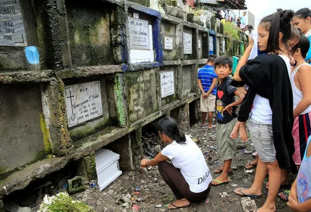 Relatives and friends gather in front of the coffin of Apolinario Eyana Jr., who was killed by unidentified men, during his burial rites inside the public cemetery in Navotas city, metro Manila, Philippines October 16, 2016. (Photo by Romeo Ranoco/Reuters)