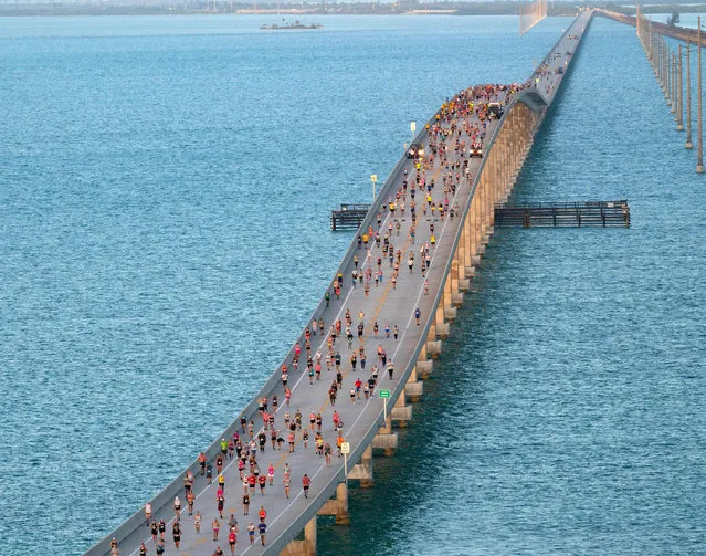 In this handout photo provided by the Florida Keys News Bureau on April 1, 2023, a portion of the field of 1,500 competitors reaches the highest point of the Seven Mile Bridge in the Florida Keys while competing in the annual Seven Mile Bridge Run near Marathon, Florida. The annual Seven Mile Bridge Run shut down the longest bridge on the Florida Keys Overseas Highway to traffic for three hours Saturday morning for the race over the convergence of the Atlantic Ocean and Gulf of Mexico. (Photo by Andy Newman/Florida Keys News Bureau via AFP Photo)