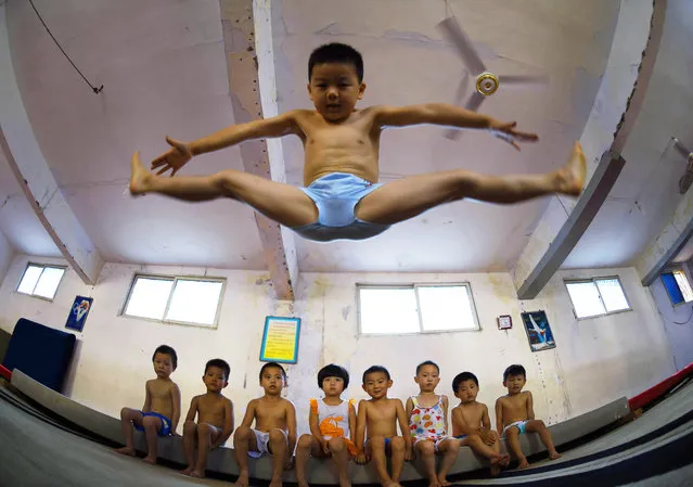 A young boy performing a straddle jump. (Photo by ChinaFotoPress/ChinaFotoPress via Getty Images)