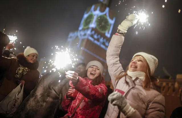 People light sparklers as they celebrate the New Year at the Red Square in Moscow, Russia, Thursday, January 1, 2015. (Photo by Denis Tyrin/AP Photo)