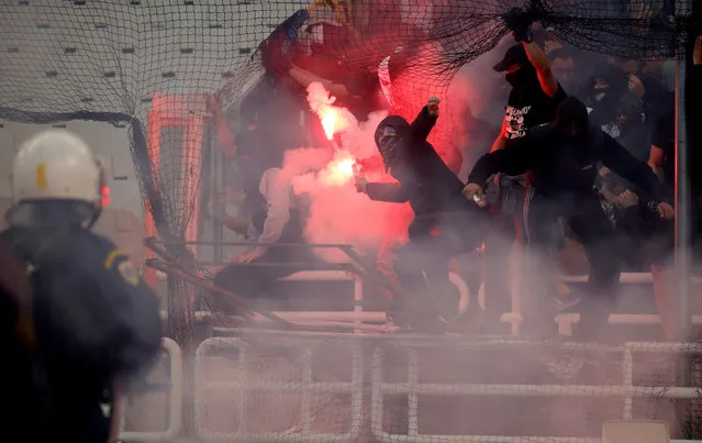 PAOK Salonika' s fans throw flares towards police officers ahead of the Greek Cup Final football match between AEK FC and PAOK Salonika at the Olympic stadium in Athens on May 12, 2018. (Photo by Alkis Konstantinidis/Reuters)
