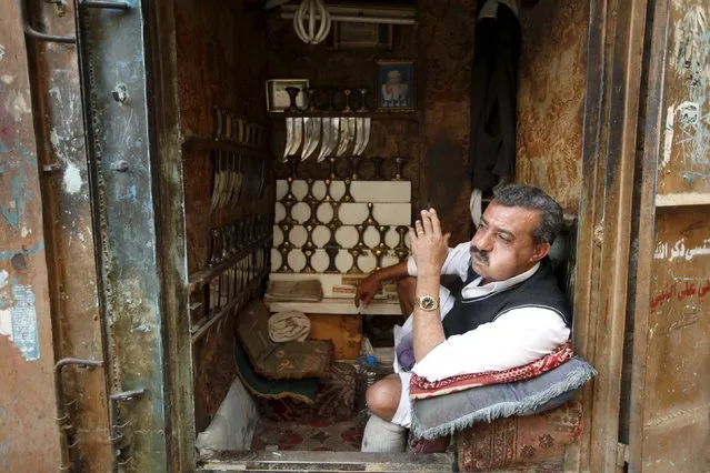 A vendor selling daggers chews qat, a mild stimulant, as he sits inside at his stall in the old quarter of Yemen's capital Sanaa November 27, 2015. (Photo by Khaled Abdullah/Reuters)