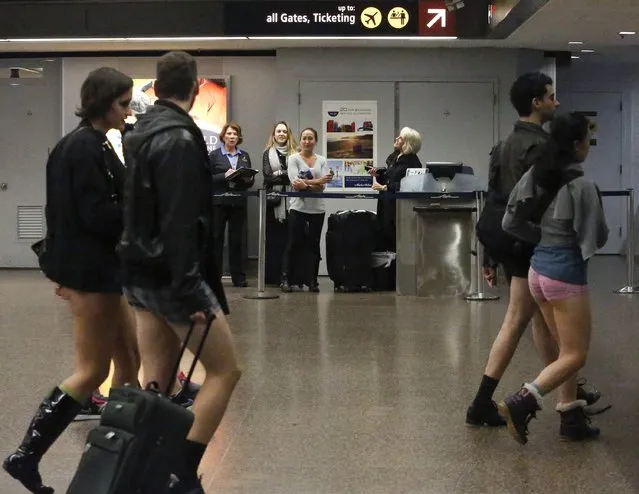 Employees at Seattle-Tacoma International Airport watch people without pants walk past during the annual No Pants Light Rail Ride organized by the Emerald City Improv group in Seattle, Washington January 11, 2015. (Photo by Jason Redmond/Reuters)