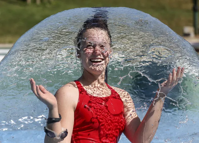 A woman refreshes herself in the outdoor pool in summer temperatures in Ehingen, Germany, Wednesday, July 29, 2020. (Photo by Thomas Warnack/dpa via AP Photo)