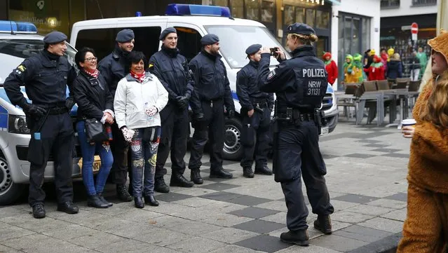 Revellers pose with police for a picture on their way to celebrate the start of the carnival season, a season of controlled raucous fun that reaches a climax during the days before Ash Wednesday and the start of Lent, at 11.11 am in Cologne, Germany, November 11, 2016. (Photo by Wolfgang Rattay/Reuters)