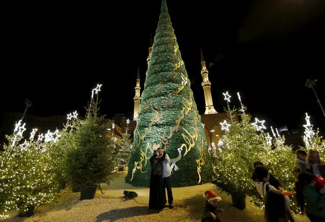 A Muslim woman takes a selfie for her family as they stand in front of a Christmas tree designed by Lebanese designer Elie Saab, in front of al Amin mosque in Beirut, Lebanon, December 12, 2015. (Photo by Jamal Saidi/Reuters)