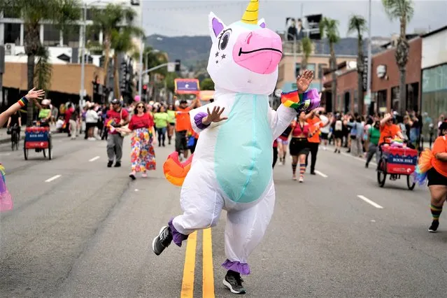 A dancer in a unicorn inflatable costume performs in the LA Pride Parade in Los Angeles Sunday, June 11, 2023. (Photo by Damian Dovarganes/AP Photo)