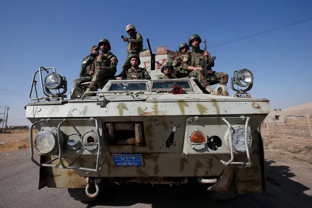 Members of Syrian Kurdish fighters ride in a military vehicle in the town of Bashiqa, after it was recaptured from the Islamic State, east of Mosul, Iraq, November 12, 2016. (Photo by Azad Lashkari/Reuters)