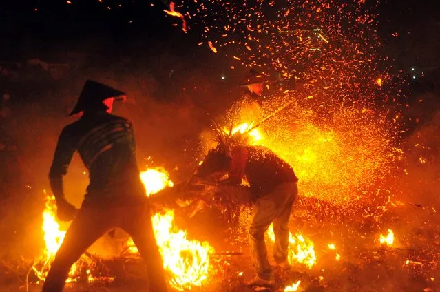 Youths play with sparks and flames from coconuts and banana leaves during a torch battle following a traditional annual event to express gratitude for the harvest and reject reinforcements at Tegalsambi village in Jepara, Central Java province, Indonesia on June 5, 2023, in this photo taken by Antara Foto. (Photo by Yusuf Nugroho/Antara Foto via Reuters)