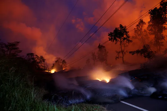 Volcanic gases rise from the Kilauea lava flow that crossed Pohoiki Road near Highway 132, near Pahoa, Hawaii, May 28, 2018. (Photo by Marco Garcia/Reuters)