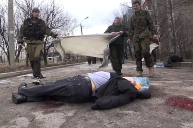 In this screen shot made available by RU-RTR, pro-Russia rebels cover a body of a victim outside clinic 27, damaged after shelling, in Donetsk, Ukraine, Wednesday, February 4, 2015. Heavy shelling in the rebel stronghold of Donetsk in eastern Ukraine on Wednesday afternoon killed at least five people and damaged a hospital, six schools and five kindergartens, local officials said. (Photo by AP Photo/RU-RTR)
