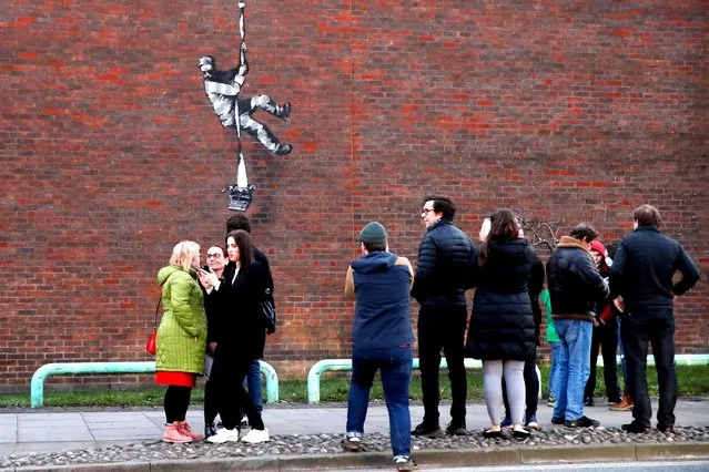 People stand in front of a suspected new mural by artist Banksy on a wall at HM Reading Prison in Reading, Britain, March 1, 2021. (Photo by Matthew Childs/Reuters)
