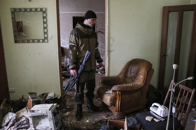 A pro-Russian separatist inspects a house, where Ukrainian troops held one of their positions, in the town of Horlivka, eastern Ukraine February 10, 2015. (Photo by Maxim Shemetov/Reuters)