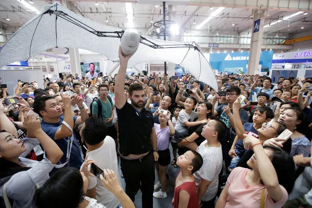 A robotic flying fox created by the German automation company Festo is carried through the crowd at the World Robot Conference (WRC) in Beijing, China on August 15, 2018. (Photo by Jason Lee/Reuters)