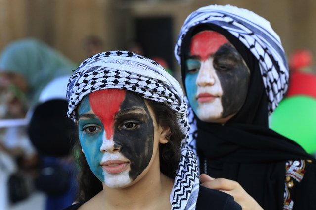 Two girls wear kefiyah, a traditional Palestinian scarf with the colors of Palestinian flag on their faces, attend an event at Ein el-Hilweh refugee camp, in the southern port city of Sidon, Lebanon, Tuesday, June 20, 2023. (Photo by Mohammed Zaatari/AP Photo)