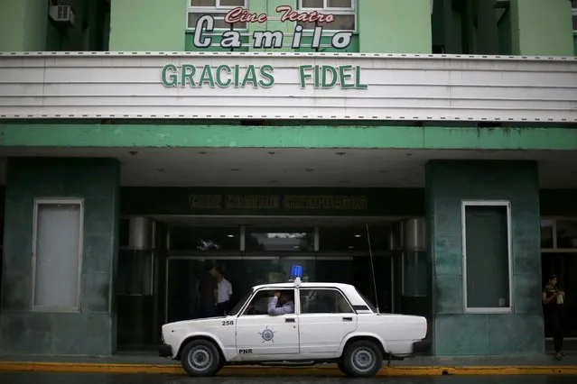 A police car sits in front of a movie theatre with a marquee reading “Thanks Fidel” as the late Fidel Castro's ashes are driven through the country in a caravan, in Santa Clara, Cuba, November 30, 2016. (Photo by Ivan Alvarado/Reuters)