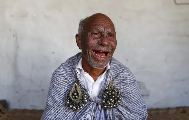 Chanda Ram, 72, a follower of Ramnami Samaj, who has tattooed the name of the Hindu god Ram on his entire face and head, poses for a picture inside his house in the village of Chapora, in the eastern state of Chhattisgarh, India, November 15, 2015. (Photo by Adnan Abidi/Reuters)