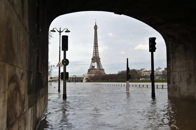View of the flooded banks of the river Seine in front of the Eiffel tower in Paris, Wednesday, January 24, 2018. The Seine River has overflowed its banks in Paris, prompting authorities to close several roads and cancel boat cruises as water levels rose at least 3.3 meters (nearly 11 feet) above the normal level. (Photo by Thibault Camus/AP Photo)