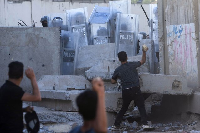 Iraqis throw stones during clashes with security forces in front of the Swedish embassy in Baghdad, Iraq, Thursday, July 20, 2023. The protest was in response to the burning of Quran in Sweden. (Phoot by Hadi Mizban/AP Photo)