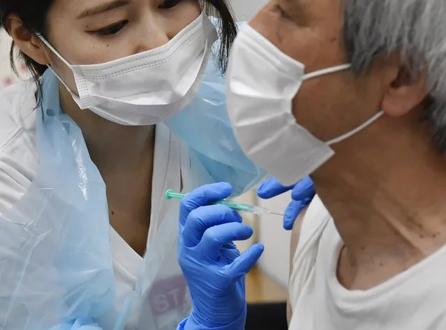 A man receives the Pfizer COVID-19 vaccine at the Noevir Stadium Kobe in Kobe, western Japan, Monday, May 31, 2021. The stadium is being used as an inoculation venue for local residents over 65 years old. Japan, seriously behind in coronavirus vaccination efforts, is scrambling to boost daily shots as the start of the Olympics in July closes in. (Photo by Yu Nakajima/Kyodo News via AP Photo)