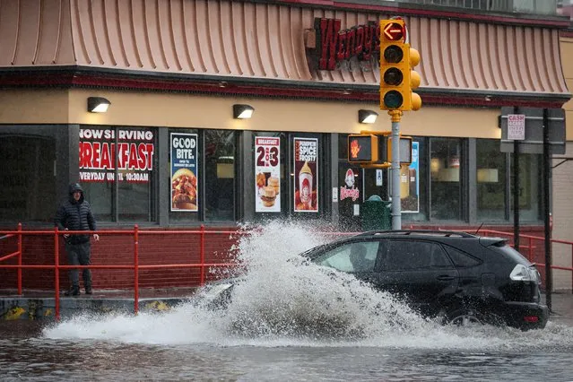 A car drives along a flooded street, as the remnants of Tropical Storm Ophelia bring flooding across mid-Atlantic and Northeast, in the Brooklyn borough of New York City, U.S., September 29, 2023. (Photo by Brendan McDermid/Reuters)