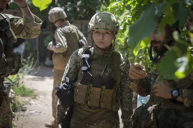 Ukrainian platoon commander Mariia talks to her soldiers in their position in the Donetsk region, Ukraine, Saturday, July 2, 2022. Ukrainian soldiers returning from the frontlines in eastern Ukraine’s Donbas region describe life during what has turned into a grueling war of attrition as apocalyptic. Mariia, 41, said that front-line conditions may vary depending on where a unit is positioned and how well supplied they are. (Photo by Efrem Lukatsky/AP Photo)