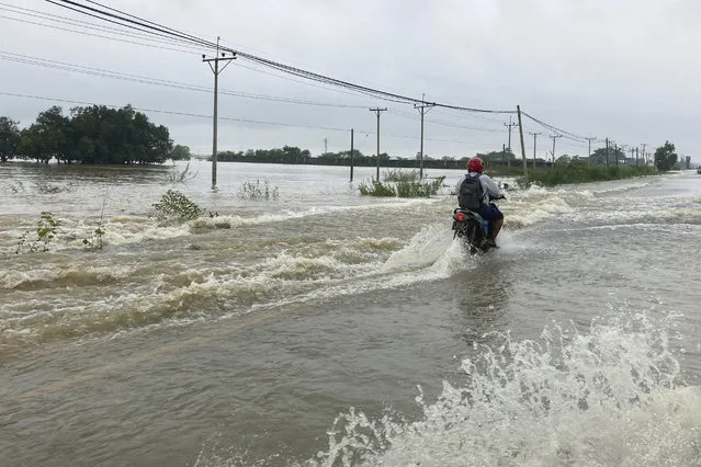 A local resident drives motorbike on a flooded road in Bago, about 80 kilometers (50 miles) northeast of Yangon, Myanmar, Monday, October 9, 2023. (Photo by Thein Zaw/AP Photo)