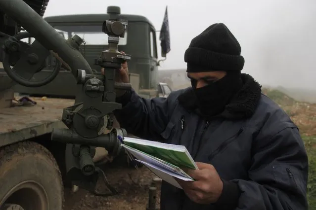 Al-Furqan brigade fighter, part of the Free Syrian Army, prepares to launch Grad rockets towards forces loyal to Syria's president Bashar Al-Assad located in Mork town, Hama countryside, from Khan Sheikoun, Idlib countryside January 17, 2015. (Photo by Mohamad Bayoush/Reuters)