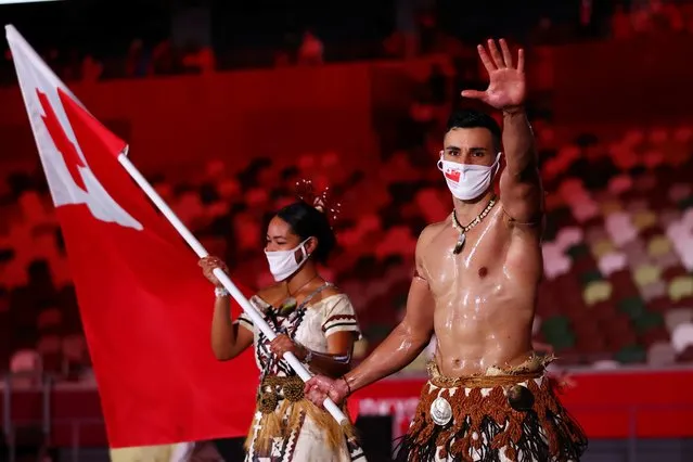 Flag bearers Malia Paseka and Pita Taufatofua of Team Tonga lead their team during the Opening Ceremony of the Tokyo 2020 Olympic Games at Olympic Stadium on July 23, 2021 in Tokyo, Japan. (Photo by Stefan Wermuth/Reuters)
