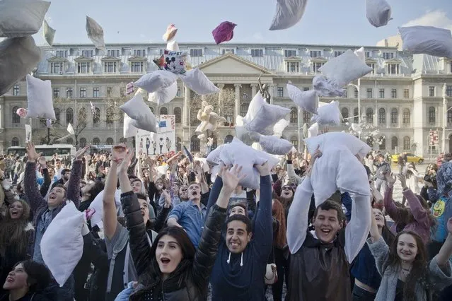 Youngsters throw pillows in the air for a photograph after taking part in a pillow fight downtown Bucharest, Romania, Saturday, April 4, 2015. Romanians took part in large numbers in the pillow fight to mark International Pillow Fight Day. (Photo by Vadim Ghirda/AP Photo)