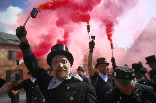 Chimney sweeps holds a smoke bombs during the The International Chimney Sweep Meeting on September 4, 2022 in Santa Maria Maggiore near Verbania, Italy. After a two year absence chimney sweeps from all over the world will meet in Vigezzo Valley, with the traditional parade taking place in Santa Maria Maggiore. (Photo by Stefano Guidi/Getty Images)