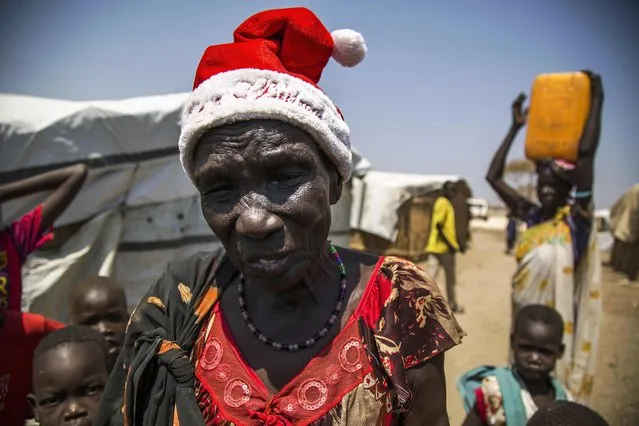 Nyakier Kuong, a displaced woman from Bentiu, is pictured at the Protection of Civilians (PoC) site in Bentiu, South Sudan, on February 16, 2016. Nyakier, who has been living in the PoC since 2014, was given this hat by her daughter from Juba last Christmas and wears it despite the searing heat to remind her of her daughter. Since the civil war in South Sudan started in December 2013, more than 120,000 people are currently living in the PoC, protected by the UN Peacekeeping Mission and assisted by UN agencies. 20,000 more displaced are also living in Bentiu town, fleeing from the ongoing conflict in their villages. (Photo by Albert Gonzalez Farran/AFP Photo)