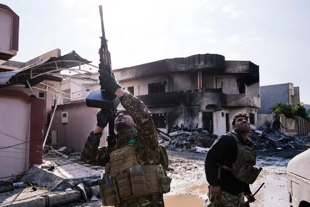 An Iraqi special forces Counter Terrorism Service (CTS) member shoots at a drone flown by Islamic State group jihadists (IS) in Mosul' s al- Rifaq neighbourhood on January 8, 2017, as an ongoing military operation against the militants continues. In the battle for Mosul drones are being used by both sides to get details on the topography, adjust their targets and to find places to plant car bombs. (Photo by Dimitar Dilkoff/AFP Photo)