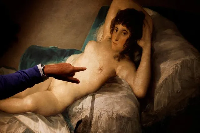 A man points at a replica of Spanish painter Francisco de Goya's “The Nude Maja” showing a mastectomized breast, as part of a joint project between the Cultura en Vena Foundation and Thyssen-Bornemisza Museum on International Breast Cancer Awareness Day, in Madrid, Spain on October 19, 2022. (Photo by Susana Vera/Reuters)