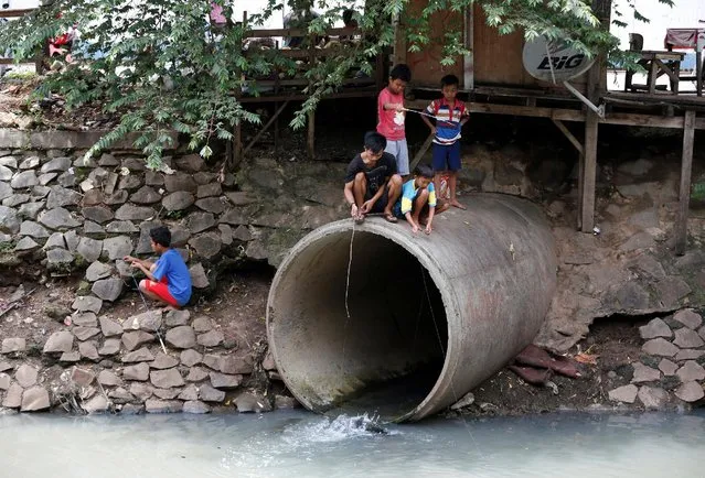 Children fish at a drainage pipe on a polluted canal in Jakarta, Indonesia November 18, 2016. (Photo by Darren Whiteside/Reuters)