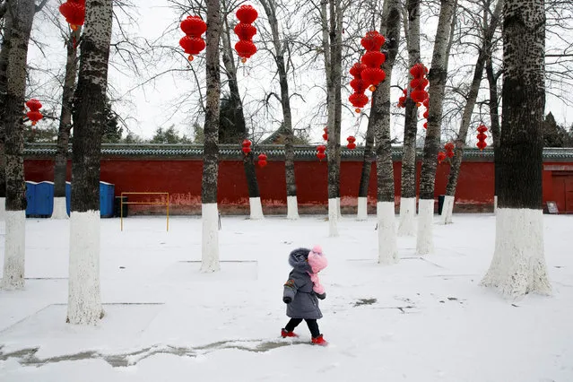 A girl draws a track into the snow in Ditan Park in Beijing, China, February 12, 2019. (Photo by Thomas Peter/Reuters)