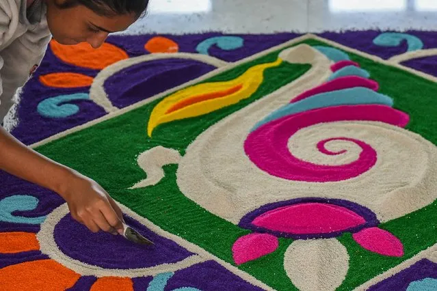A college student makes “Rangoli” which is a Hindu ritual art design during an event in Amritsar on October 26, 2021. (Photo by Narinder Nanu/AFP Photo)