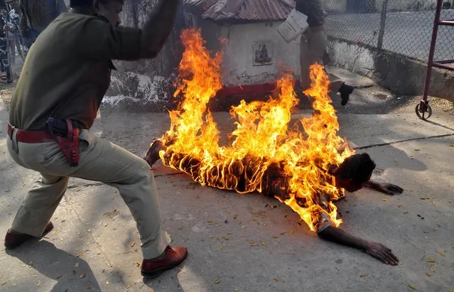 Pranab Boro, an activist of Krisak Mukti Sangram Samiti (KMSS) self-immolates in a protest demanding land rights for local people in various regions of eastern Assam state, in front of the Assam Secretariat in Guwahati on February 24, 2014. Boro died after hospitalisation with burns covering over 90 percent of his body. (Photo by Chinmoy Roy/AFP Photo)
