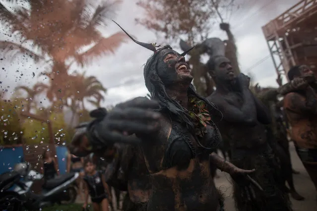 Revelers participate in the traditional 28th  Bloco da Lama (Mud block) carnival in  on March 1, 2014 Parati, Rio de Janeiro State, Brazil. The event, which was begun by two men in a playful manner in 1986, has now become a traditional carnival in which participants disguised as primitives with rags, lianas or skulls and bones, dive in the mud. (Photo by Victor Moriyama/Getty Images)