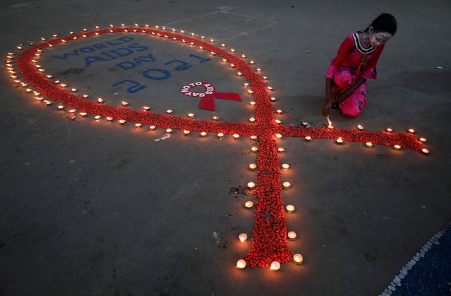 A girl lights earthen lamps during an HIV/AIDS awareness campaign on the occasion of World AIDS Day in Kolkata, India, December 1, 2021. (Photo by Rupak De Chowdhuri/Reuters)