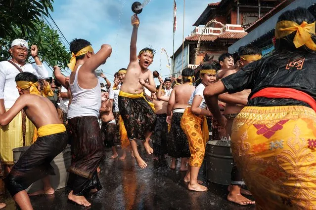 Balinese Hindu children throw water at each other during a ritual a day after Nyepi, the day of silence that marks the New Year in the Balinese Hindu calendar, in Jimbaran, Bali, on March 12, 2024. (Photo by Yasuyoshi Chiba/AFP Photo)