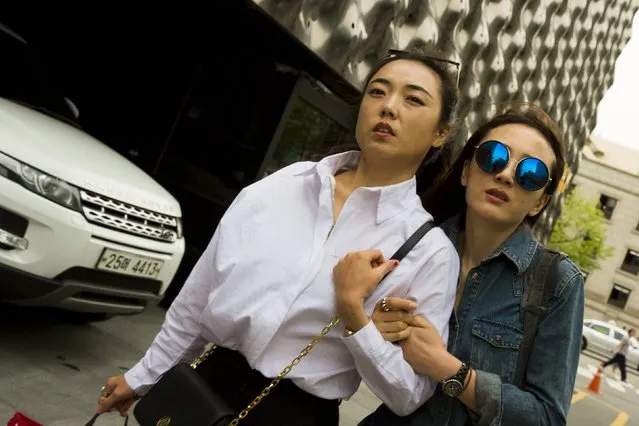 Women walk down a street in the fashion district of Apgujeong in Seoul, May 7, 2015. (Photo by Thomas Peter/Reuters)
