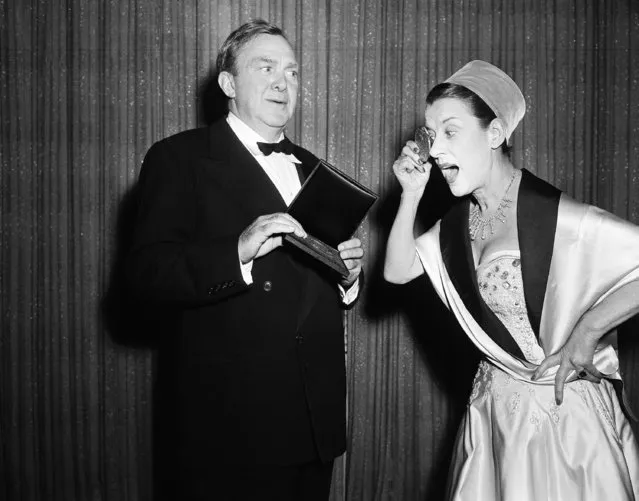 Actress Beatrice Lillie, British star, uses her Tony medallion as a monocle to look at the medallion held by Thomas Mitchell after both of them were honored at the American Theater Wing's presentation of awards at New York's Waldorf-Astoria Hotel, March 29, 1953. The British star received a special award for her performances through the years and her current performance in “An Evening with Beatrice Lillie”. Mitchell received his Tony as the best actor a in musical for his performance in “Hazel Flagge”. (Photo by Marty Lederhandler/AP Photo)