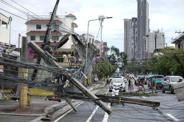 Toppled electrical posts lie along a street in Cebu city, central Philippines caused by Typhoon Rai on Friday, December 17, 2021. A powerful typhoon slammed into the southeastern Philippines on Thursday, toppling trees, ripping tin roofs and knocking down power as it blew across island provinces where nearly 100,000 people have been evacuated. (Photo by Jay Labra/AP Photo)