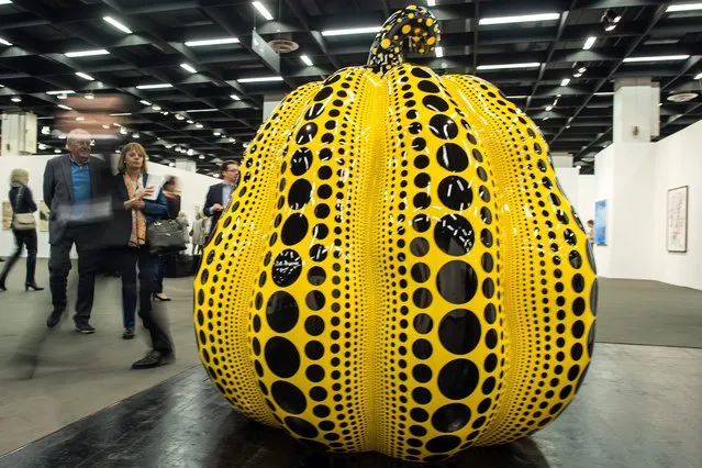 A visitor walks past the piece “Pumpkin” from by Yayoi Kusama in Cologne, Germany, 13 April 2016. The largest art fair in Germany takes place for the 50th time in Cologne. On show are contemporary works and modern classics. (Photo by Federico Gambarini/EPA)