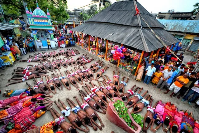 Hindu devotees seen offering their prayer towards Hindu Lord Shiva as per the traditional ritual of Charak Festival at a village near Bagnan in India on April 13, 2024. Charak Festival is one of the oldest Folk festivals as devotees show their faith by self inflicting pain in the belief that Lord Shiva will help them overcome troubles in their daily lives. (Photo by Avishek Das/SOPA Images/Rex Features/Shutterstock)